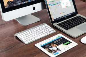 Computer setup voor goedkope webhosting - werkplek voor websitebeheersysteem met MacBook en iMac